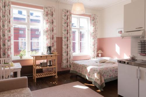 ein Schlafzimmer mit einem Bett und zwei Fenstern in der Unterkunft Huoneistohotelli Marja in Mikkeli