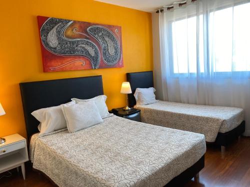 a hotel room with two beds and a painting on the wall at Hotel Porto Rico in Porto