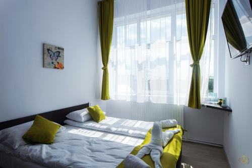 a bedroom with a bed with yellow sheets and a window at Antari in Slatina
