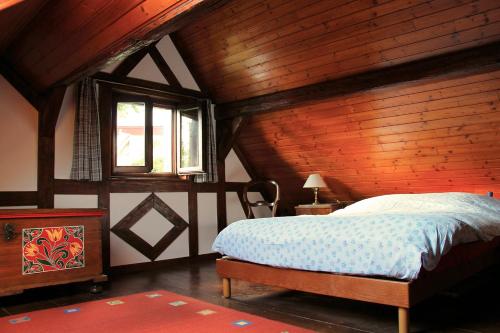 a bedroom with a bed and a wooden ceiling at le jardin du rempart in Westhoffen