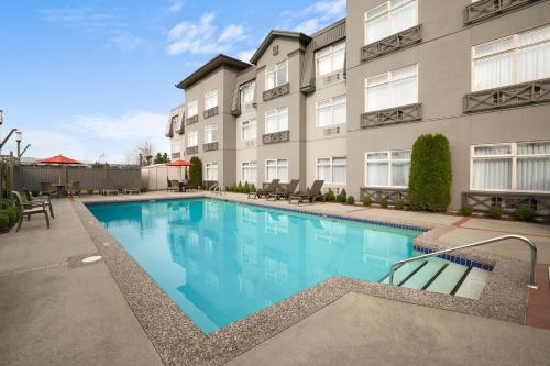 a swimming pool in front of a building at Best Western Plus Pitt Meadows Inn & Suites in Pitt Meadows