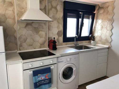 a kitchen with a washing machine and a sink at Camarote de la Villa in Bueu