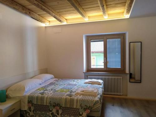a bedroom with a bed and a window at Affitta camere Casa Vittoria in Santa Croce del Lago