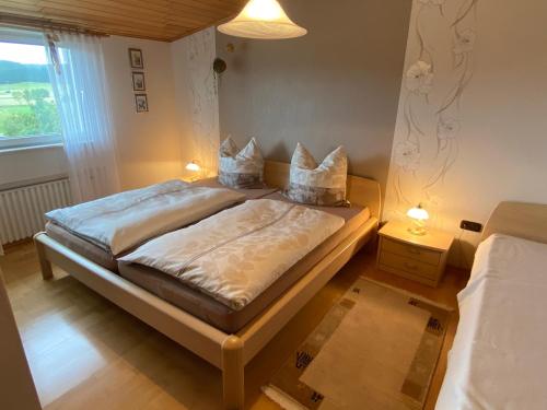 een slaapkamer met een bed met 2 lampen en een raam bij Pension Görgen in Herresbach