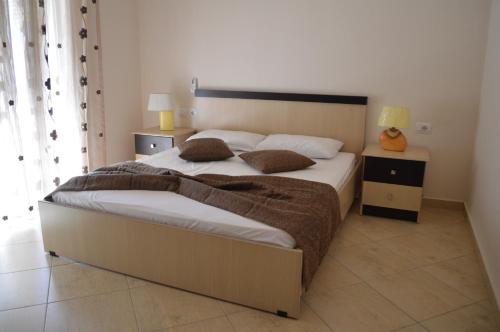 a bedroom with a large bed with white sheets and pillows at Hotel Ana in Përmet