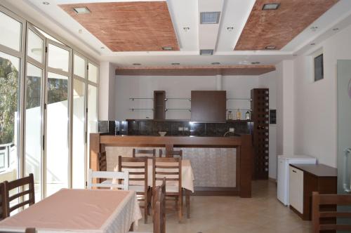 a dining room with a table and chairs and windows at Hotel Ana in Përmet