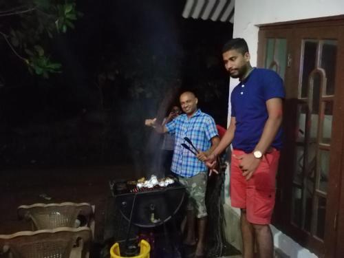 two men standing in front of a grill at Dambulla City Hostel in Dambulla