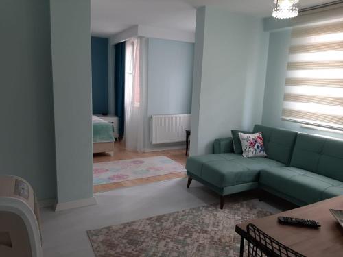 a living room with a green couch and a table at Samlife Apart in Samsun