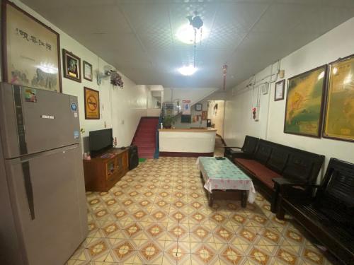 a living room with a couch and a table and a refrigerator at Wayu House in Dawu
