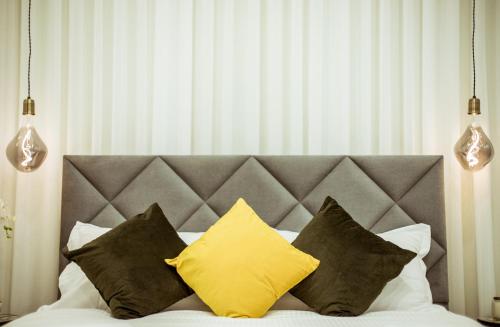 a bed with a bunch of pillows on it at The Negev Hotel By Domus in Beer Sheva