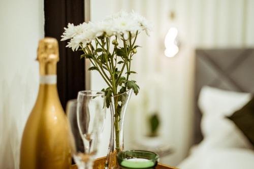 a vase with white flowers in it on a table at The Negev Hotel By Domus in Beer Sheva