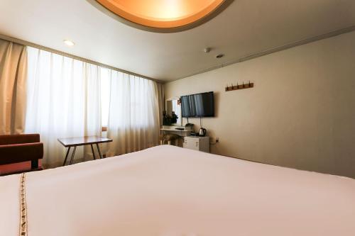 a bedroom with a large white bed and a window at Nova Motel in Boryeong