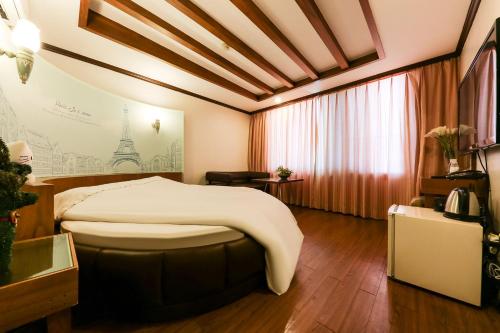 ボリョンにあるNova Motelの大きなベッドと窓のあるホテルの部屋