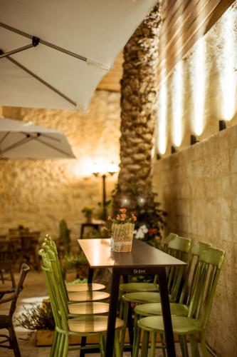 a table with green chairs and a table with an umbrella at The Negev Hotel By Domus in Beer Sheva
