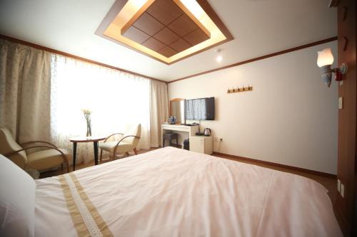 a bedroom with a large white bed and a window at Nova Motel in Boryeong