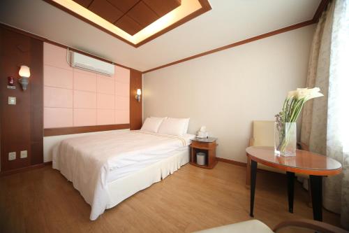 a bedroom with a white bed and a table at Nova Motel in Boryeong