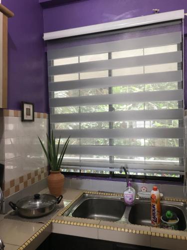 a kitchen with a sink and a window with blinds at David beachside apartment in Port Dickson