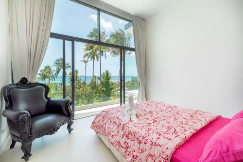 a bedroom with a bed and a chair and a window at Villa Zen Sushi in Lamai