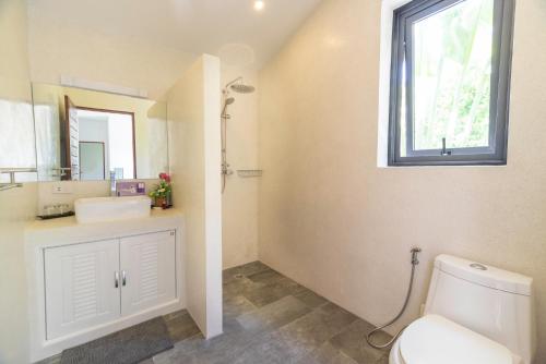 a bathroom with a toilet and a sink and a window at Villa Zen Sushi in Lamai