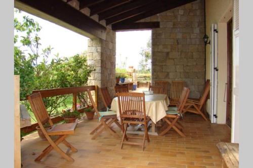 - une terrasse couverte avec une table et des chaises dans l'établissement Maison de charme proche mer en Corse du Sud, à Sollacaro