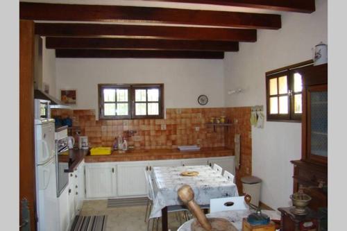 una cucina con tavolo al centro di Maison de charme proche mer en Corse du Sud a Sollacaro