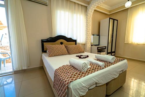 a bedroom with a large bed with pillows on it at Elvin Otel in Side