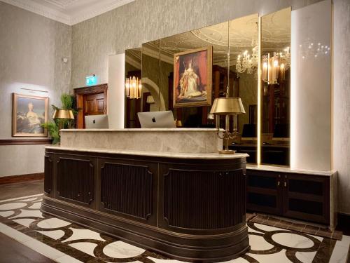 a lobby with a reception desk in a building at Mottram Hall in Macclesfield