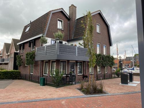 a large brick building with a black roof at B&B de Nieuwe Haven in Bunschoten