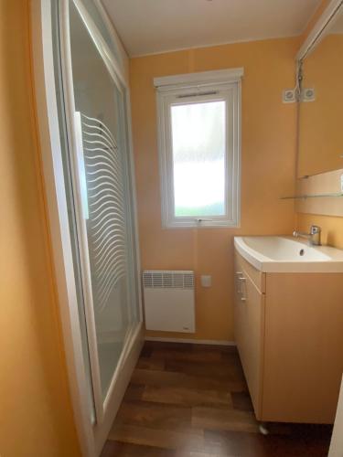 ein Badezimmer mit Dusche und Waschbecken und einem Fenster in der Unterkunft MOBIL HOME 43 dans Camping 4 Etoiles in Gastes