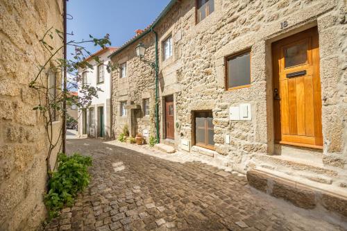 an alley with stone buildings and a wooden door at Casa da Pedra - Monsanto in Monsanto