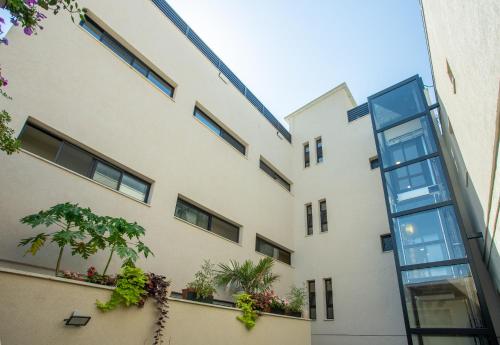 an exterior view of a building with potted plants at The Negev Hotel By Domus in Beer Sheva