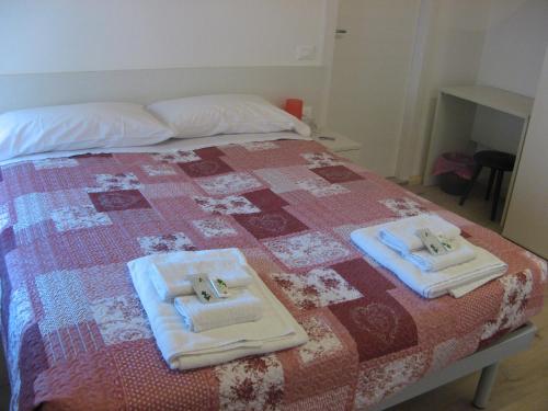a bed with two towels on top of it at Affitta camere Casa Vittoria in Santa Croce del Lago