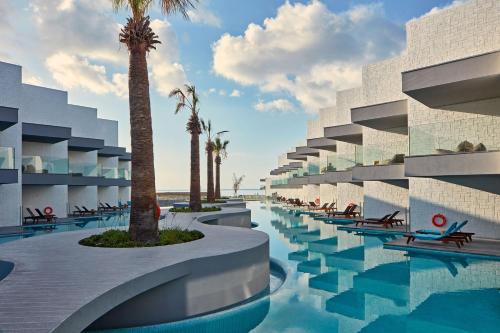 un hôtel doté d'une piscine et de palmiers dans l'établissement Atlantica Dreams Resort, à Gennadi