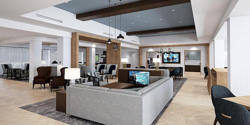 Staybridge Suites - Denver North - Thornton, an IHG Hotel في ثورنتون: غرفة معيشة مع أريكة وكراسي
