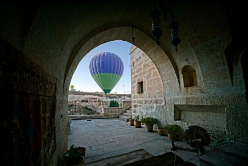 a hot air balloon flying through an arch way at Fairyland Cave Hotel in Goreme