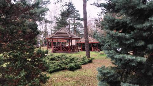 a wooden gazebo in the middle of a forest at Hotel U Witaszka in Czosnów