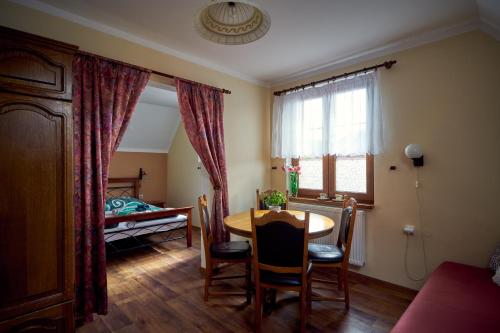 a dining room with a table and a bedroom at Penzion Na Hradčanech in Nové Město nad Metují