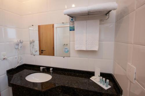 a bathroom with a sink, toilet and mirror at Bristol Centro Civico Hotel in Curitiba