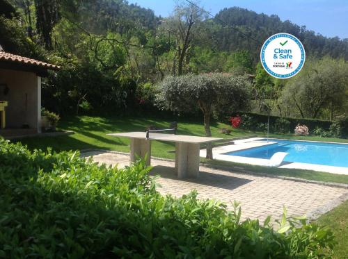 a stone bench next to a swimming pool at Geres Nature House, casa das pedras in Vieira do Minho