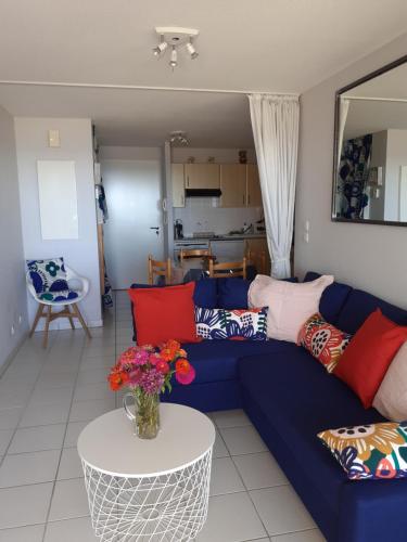 a blue couch in a living room with a table at Les Goélands de l'Océan in Vieux-Boucau-les-Bains