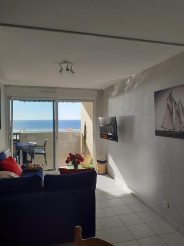 a living room with a couch and a view of the ocean at Les Goélands de l'Océan in Vieux-Boucau-les-Bains