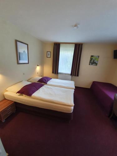 a bedroom with a large bed and a couch at Hotel Bergschlösschen in Boppard