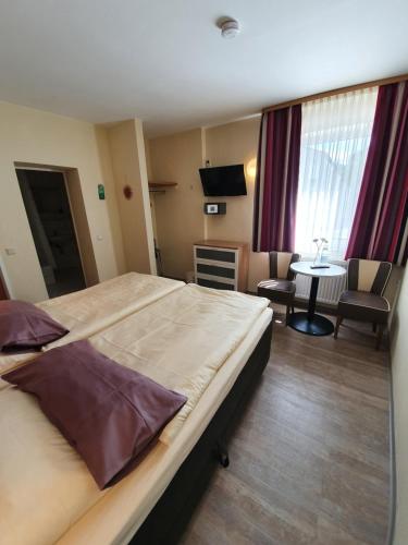 a hotel room with a large bed and a table at Hotel Bergschlösschen in Boppard