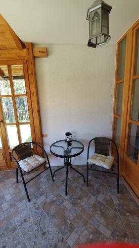 une chambre avec une table, deux chaises et une lampe dans l'établissement Vila Panić Zlatibor, à Zlatibor