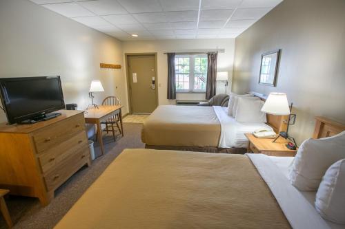a hotel room with two beds and a flat screen tv at Lodging on the Square in Berlin