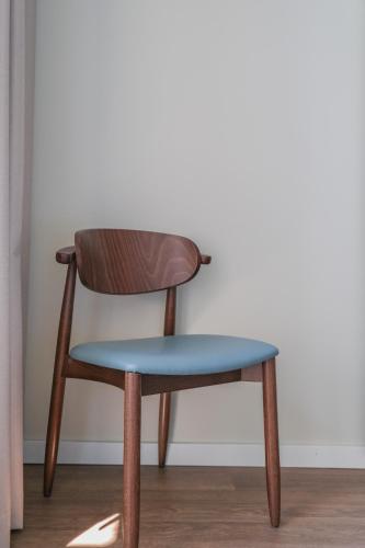 a wooden chair with a blue seat in a room at Hotel Vouga in Termas de Sao Pedro do Sul