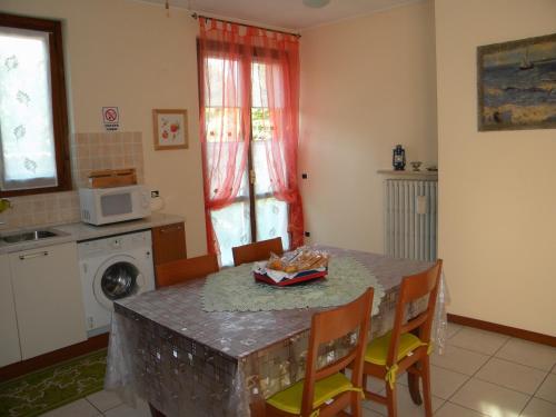 een keuken met een tafel met stoelen en een magnetron bij il tasso in Mapello