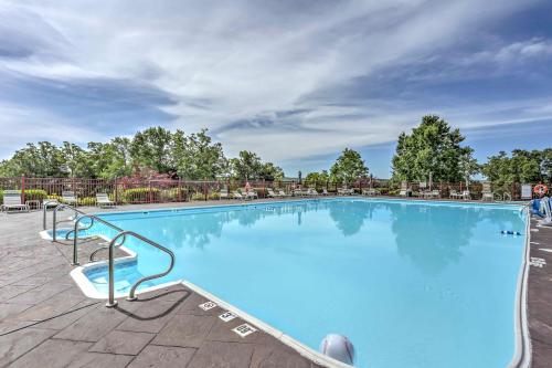 a large blue swimming pool with chairs and trees at Family Resort Condo with Perks in Branson! in Branson