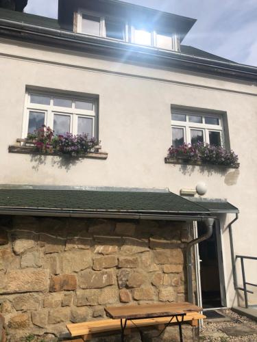 a building with two windows and a bench in front of it at Hrensko31 in Hřensko