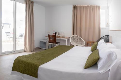 a bedroom with a large bed and a balcony at Hotel Senderos in Agua Amarga